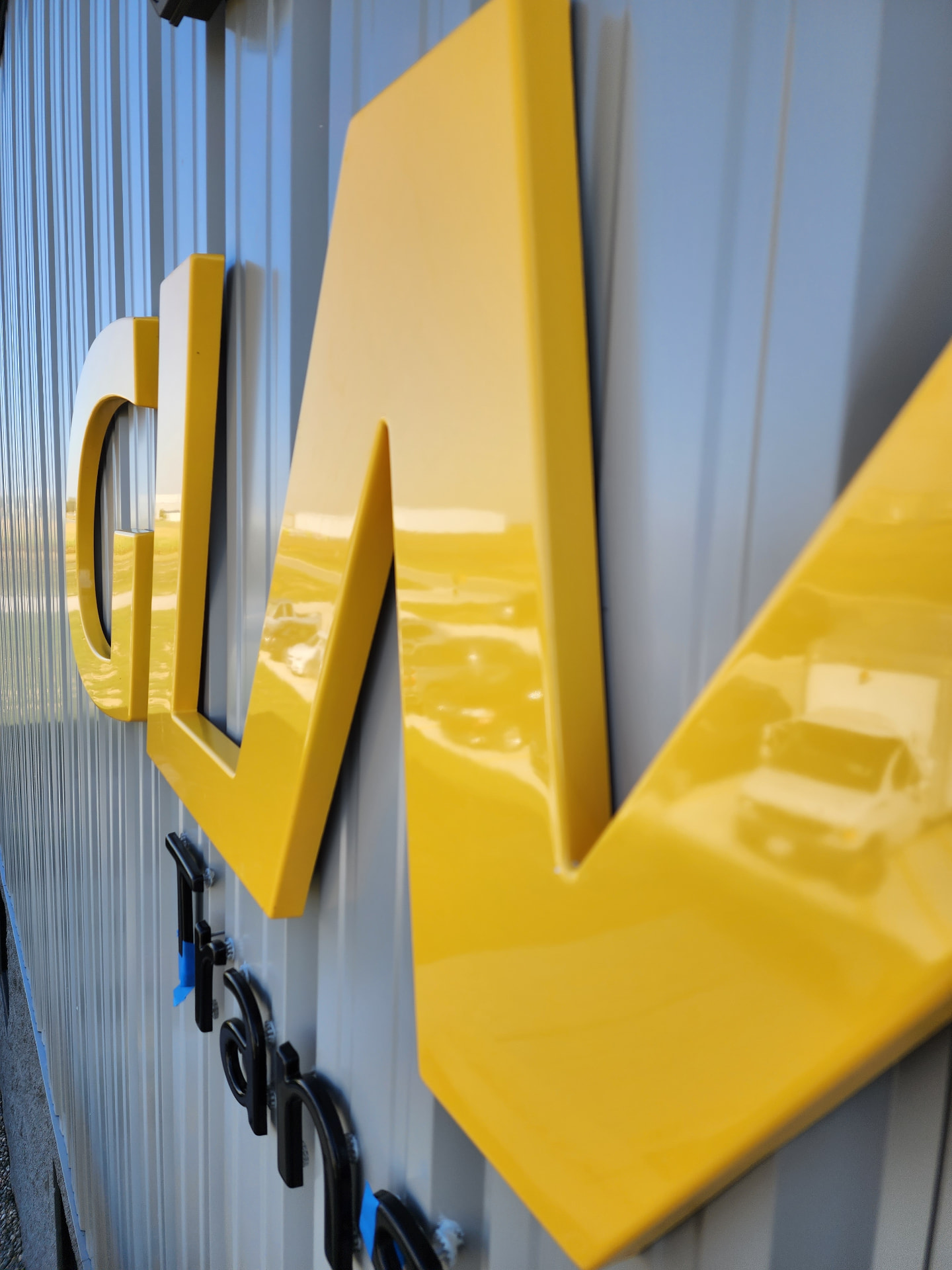 Custom dimensional yellow storefront lettering being installed